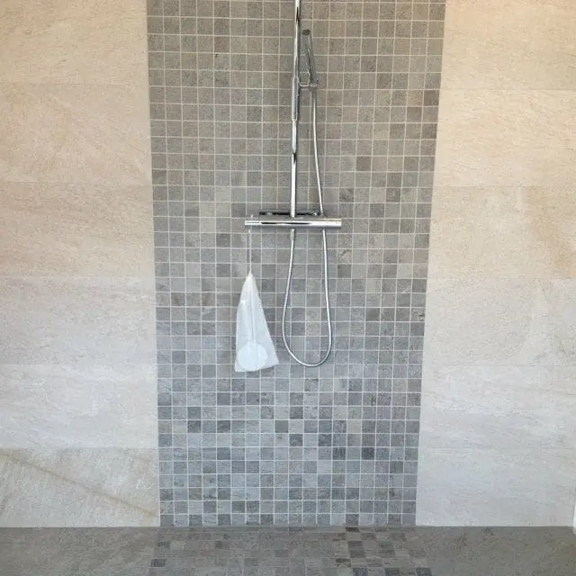 Dusj med mosaikkfliser og beige veggfliser
