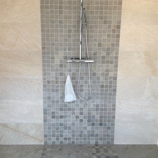 Dusj med mosaikkfliser og beige veggfliser
